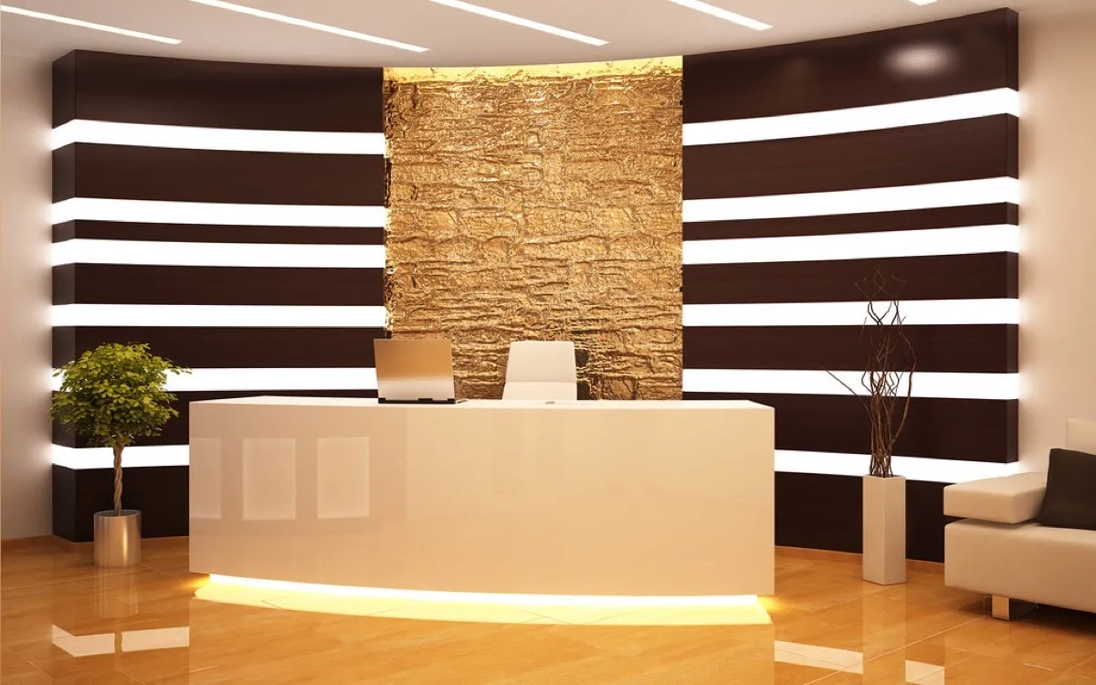 An empty hotel reception desk in a warmly lit lobby