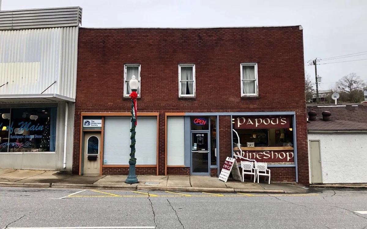 A small brick shopfront on a quiet main street, seen from across the road