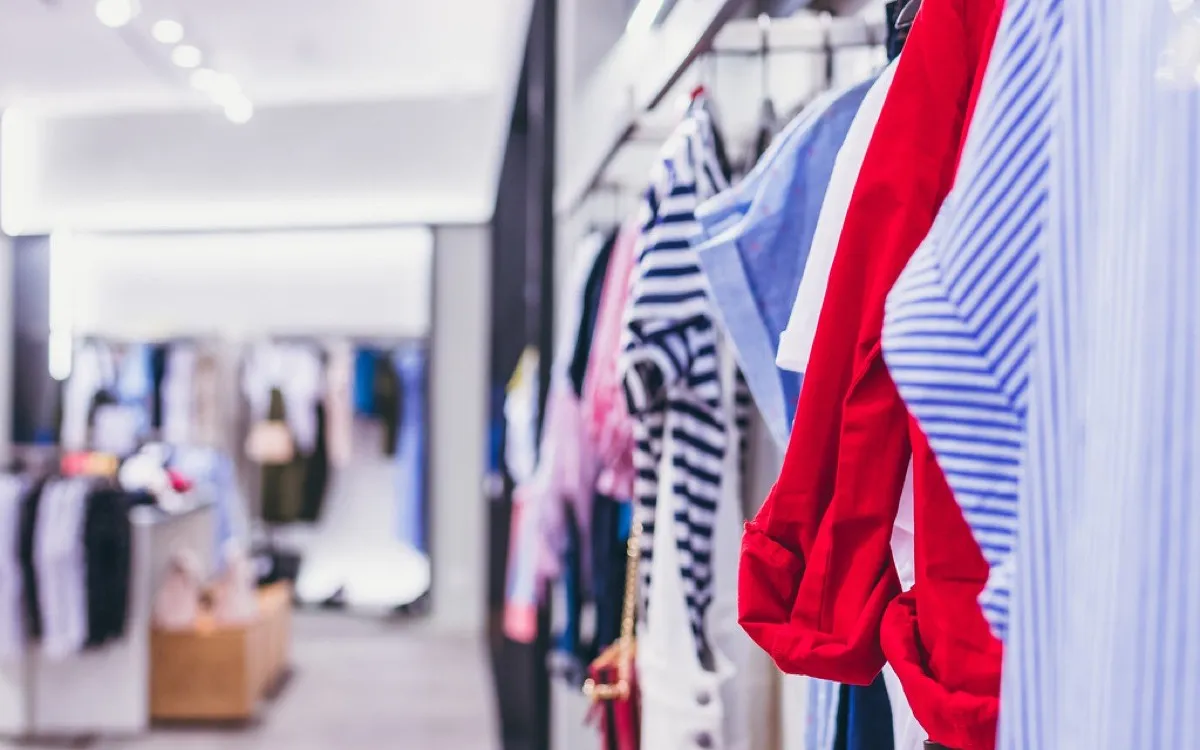 A rail of striped and red shirts in a boutique, other rails behind